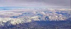 Sunset Mountain Prints: Aerial view from airplane of the Wasatch Front Rocky Mountain Range with snow capped peaks in winter including urban