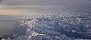 Sunset Mountain Prints: Aerial view from airplane of the Wasatch Front Rocky Mountain Range with snow capped peaks in winter including urban
