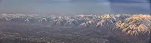 Sunset Mountain Prints: Aerial view from airplane of the Wasatch Front Rocky Mountain Range with snow capped peaks in winter including urban