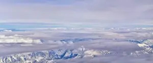 Sunset Mountain Prints: Aerial view from airplane of the Wasatch Front Rocky Mountain Range with snow capped peaks in winter including urban