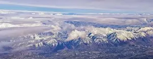 Sunset Mountain Prints: Aerial view from airplane of the Wasatch Front Rocky Mountain Range with snow capped peaks in winter including urban