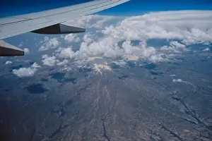Aerial view from airplane window of clouds and mountain landscape Middle East