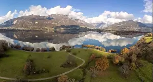 Lake Como Prints: Aerial view of an alpine lake and the surrounding mountains and vegetations reflected on a cloudy day