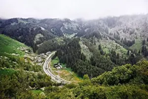 Almaty Prints: Aerial view of the alpine village and river in the mountains at foggy clouds