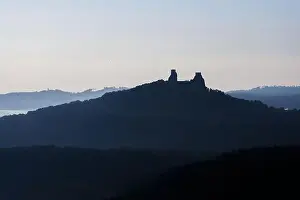 Baba Prints: Aerial view of ancient ruined Trosky Castle high on summits of two basalt volcanic plugs on background of autumn