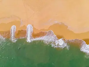 Aerial view of a beach and waves along the sea