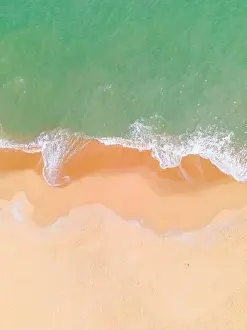 Aerial view of a beach and waves along the sea