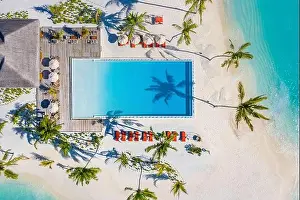 Aerial view of beautiful hotel summer landscape sea shore, coast, azure sea water, sandy beach, palm trees infinity pool, chairs, beds. Luxury resort
