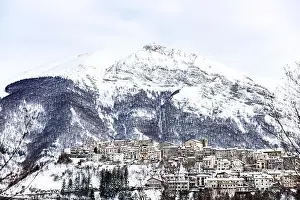 Aerial view of the beautiful snow-covered village of Opi with snow-capped mountains in the background