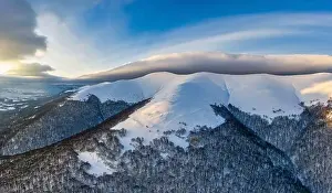 Wintersport Prints: Aerial view of beautiful winter mountain slopes covered with snow and firs forest on a sunny cloudless day
