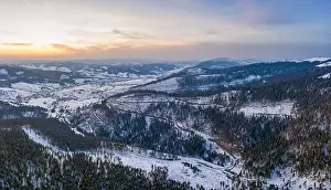 Wintersport Prints: Aerial view of beautiful winter mountain slopes covered with snow and firs forest on a sunny cloudless day