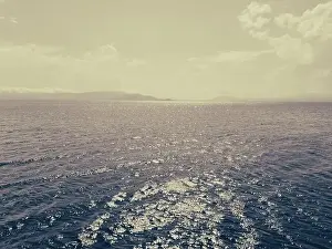 Aerial view of a blue sea water background and sun reflections