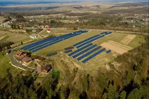 Aerial view of blue solar photo voltaic panels system producing renewable clean energy on rural landscape