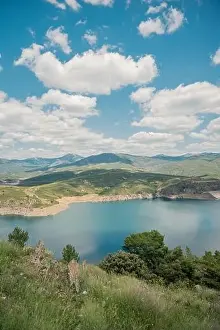 Aerial view of breathtaking scenery of calm lake with water located in mountainous valley with green trees