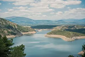 Aerial view of breathtaking scenery of calm lake with water located in mountainous valley with green trees