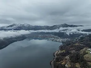Trentino Prints: Aerial view of Caldonazzo Lake with snowy mountain peaks and misty valleys