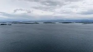 Calm Sea Prints: Aerial view of a calm sea with scattered small islands under a cloudy sky