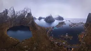 Inhabited Prints: Aerial view of calm water of sea washing island with rocky formations under cloudy sky