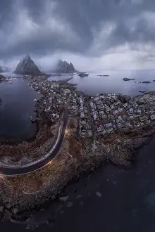 Inhabited Prints: Aerial view of calm water of sea washing island with a village and rocky formations under cloudy sky