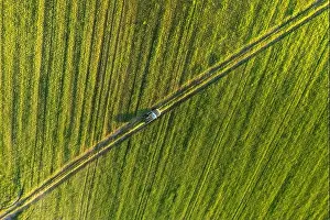 Aerial view of car SUV parked near countryside road in field rural landscape. Bird's-eye drone view of car SUV parked near countryside road in summer