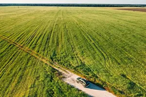 Aerial view of car SUV parked near countryside road in field rural landscape. Bird's-eye drone view of car SUV parked near countryside road in summer