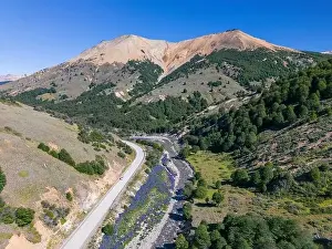 Lila Prints: Aerial view of the Carretera Austral with a crystal clear creek along the road and forested hills