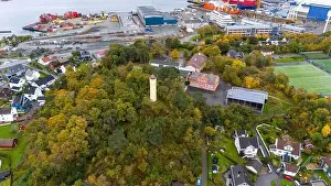 Aerial view of a coastal town with a lighthouse surrounded by trees