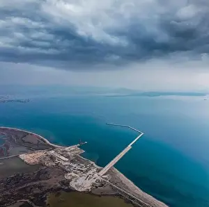 Unloading Prints: Aerial view of a Construction of a marina from a drone with blue sea water and clouds on sky