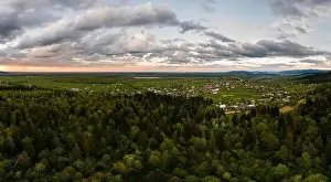 Aerial view of dark mountain hills covered with green mixed pine and lush forest in evening