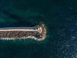 Chania Prints: Aerial top view by drone of iconic Venetian lighthouse in the entrance of picturesque old port of Chania at sunset