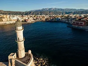 Chania Prints: Aerial top view by drone of iconic Venetian lighthouse in the entrance of picturesque old port of Chania at sunset