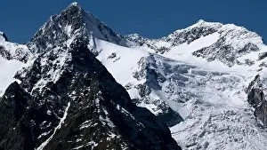Aerial view of epic winter snow covered mountains on a blue background. Creative. Sharp slopes and cliffs