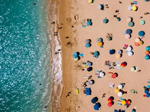 Beachfront Prints: Aerial View From Flying Drone Of People Crowd Relaxing On Algarve Beach In Portugal
