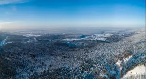 Hoar Prints: Aerial view of the forest and river at winter. The trees are covered with snow