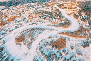 Aerial view forest woods and river landscape in winter day. Bird's eye view of small island and curved river landscape in winter day. Top view of