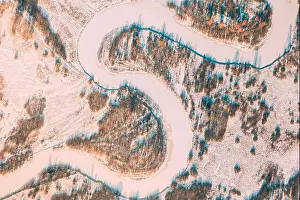 Aerial view forest woods and river landscape in winter day. Top view of beautiful european nature from high attitude in winter season. Bird's eye view