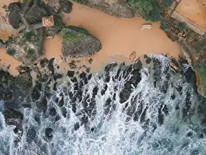 Sea Cliff Prints: Top down aerial view of giant ocean waves crashing and foaming in coral beach