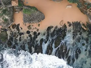 Sea Cliff Prints: Top down aerial view of giant ocean waves crashing and foaming in coral beach