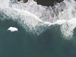 Yogyakarta Prints: Top down aerial view of giant ocean waves crashing and foaming in coral beach