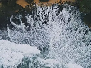 Yogyakarta Prints: Top down aerial view of giant ocean waves crashing and foaming in coral beach