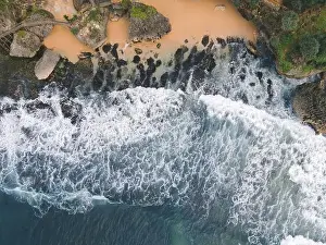 Yogyakarta Prints: Top down aerial view of giant ocean waves crashing and foaming in coral beach