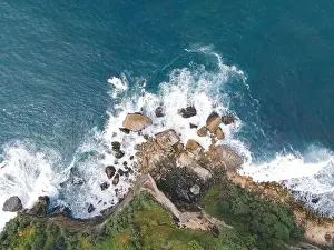 Yogyakarta Prints: Top down aerial view of giant ocean waves crashing and foaming in coral beach