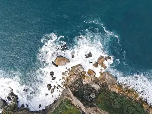 Yogyakarta Prints: Top down aerial view of giant ocean waves crashing and foaming in coral beach