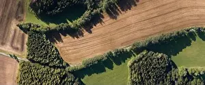 Discovering Prints: Aerial view of a green agricultural field with a rural road passing through it