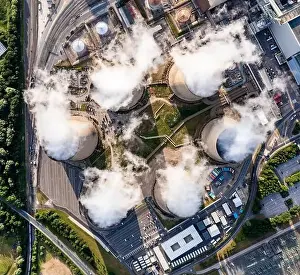 Directly Above Prints: Aerial top down view of a group of cooling towers emitting steam at a large coal fired power station