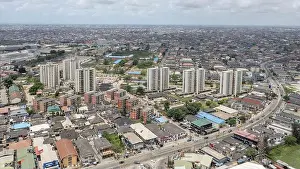 Nigerian Prints: Aerial view of high-rise buildings contrasting with the sprawling urban landscape