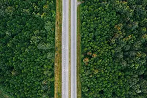 Aerial View Of Highway Road Through Green Forest Landscape In Summer. Top View Flat View Of Highway Motorway Freeway From High Attitude. Trip And Trav