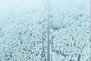 Aerial Landscape Collection: Aerial view of highway road through snow forest landscape in winter