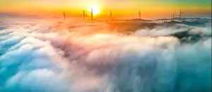 Morning Glow Prints: Aerial view top hill at dawn with fog covering small village in valley