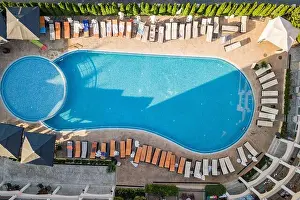 Tropical Climate Prints: Top down aerial view of hotel swimming pool with crystal blue water surrounded with palm trees